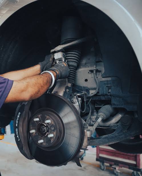 Mechanic performing suspension repair service on a car in UAE workshop